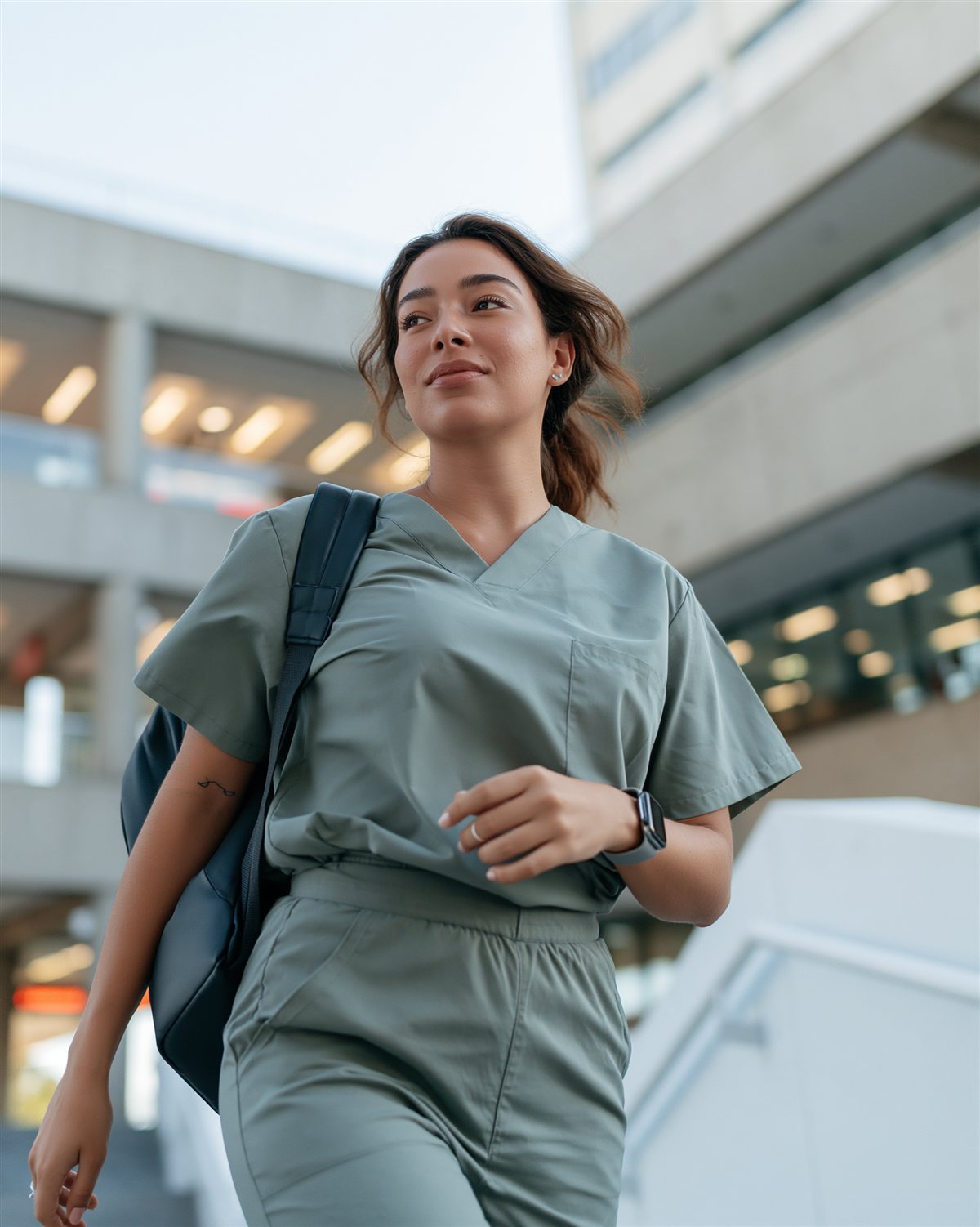 Mulher de uniforme hospitalar caminhando ao ar livre